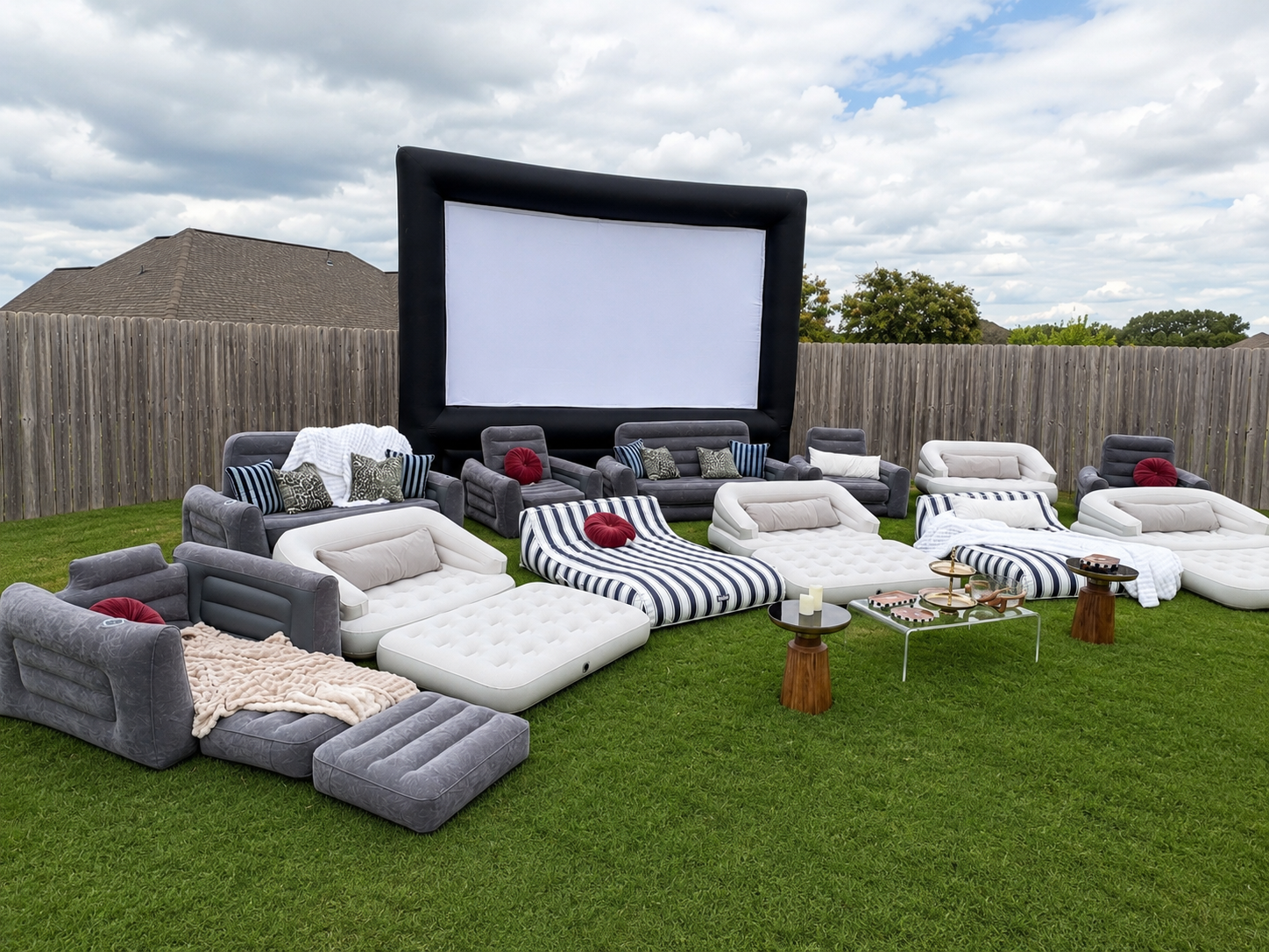 The Gatsby setup with a large inflatable movie screen and a wide semi-circle of inflatable couches, loungers, and styled tables for twenty guests